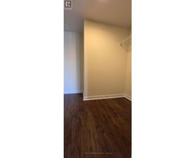 A room with wooden flooring and white walls.