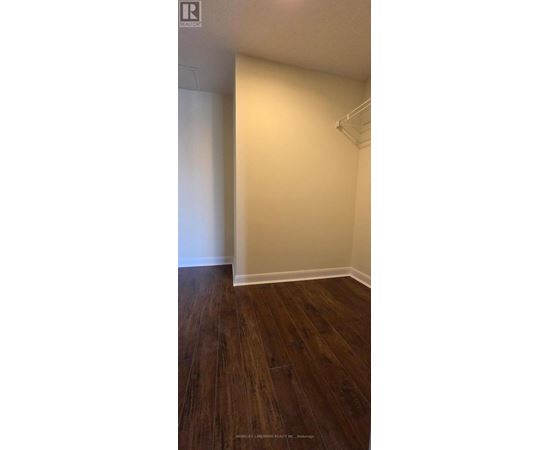 A room with wooden flooring and white walls.