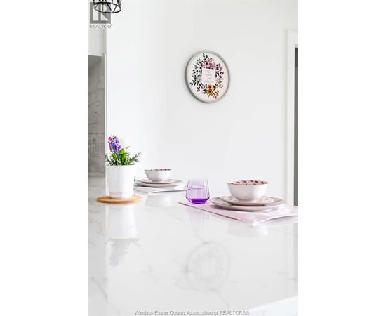 A white table with a bowl of cereal and a plant on it.