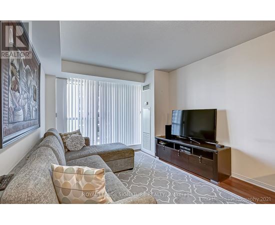 A living room with a grey couch and a television.