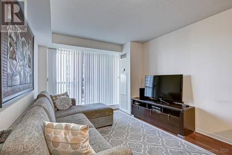 A living room with a grey couch and a television.