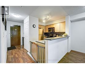 A kitchen with white cabinets and a wooden floor.