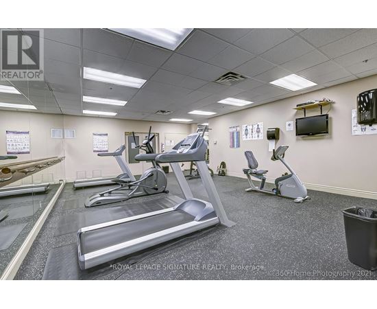 A gym with treadmills, exercise bikes, and a television.