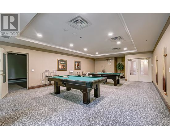 A room with a pool table and a carpet.