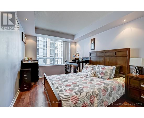 A bedroom with a large bed and a window overlooking a cityscape.