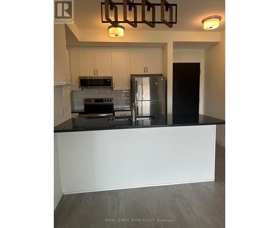 A kitchen with a stove top oven, microwave, and refrigerator.