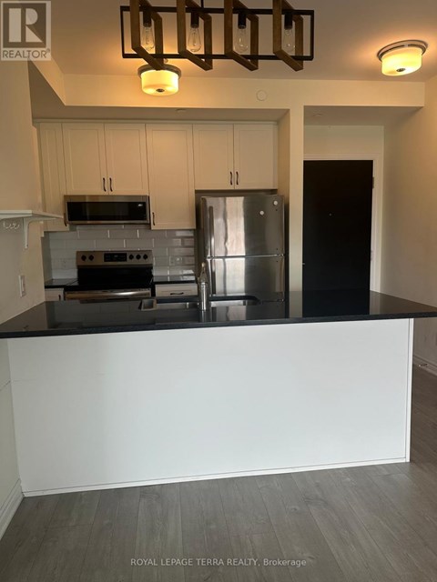 A kitchen with a stove top oven, microwave, and refrigerator.