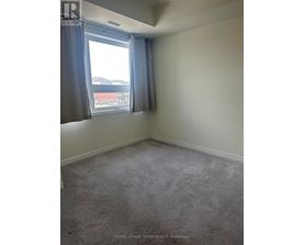 A room with a carpeted floor and a window with curtains.