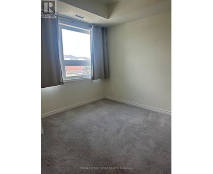 A room with a carpeted floor and a window with curtains.