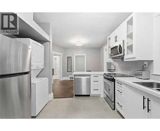 A modern kitchen with white cabinets and stainless steel appliances.