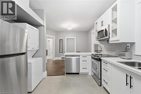 A modern kitchen with white cabinets and stainless steel appliances.