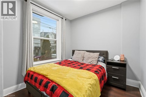 A bedroom with a bed, nightstand, and window.