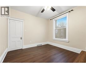 A room with a white door and a window with a view of trees outside.