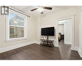 A living room with a flat screen TV and a ceiling fan.