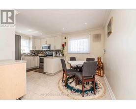 A kitchen with a dining table set up in the middle.