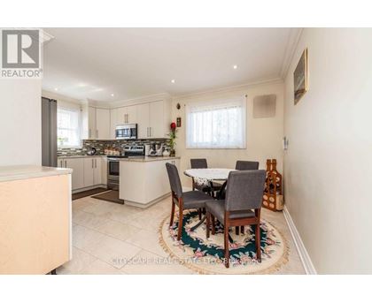 A kitchen with a dining table set up in the middle.
