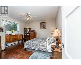 A bedroom with a bed, dresser, and ceiling fan.