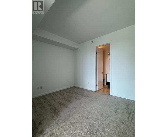 A room with a carpeted floor and a doorway leading to another room.