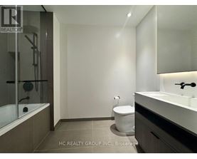 A bathroom with a toilet, sink, and bathtub.