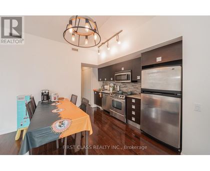 A kitchen with a dining table set up with orange tablecloth and a signboard on the table.