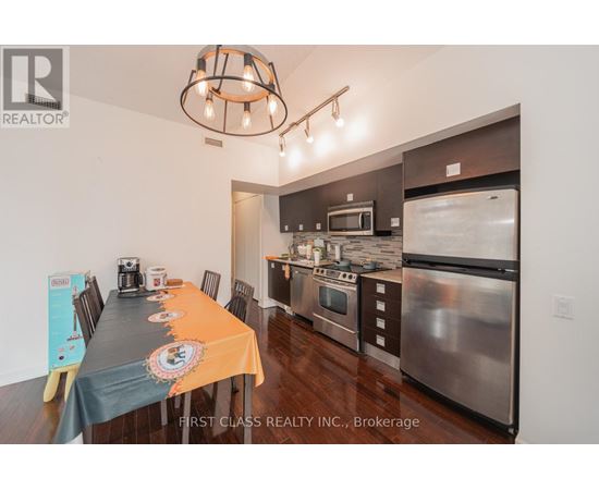 A kitchen with a dining table set up with orange tablecloth and a signboard on the table.