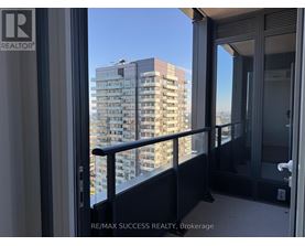 A balcony with a glass door overlooking a high-rise building.
