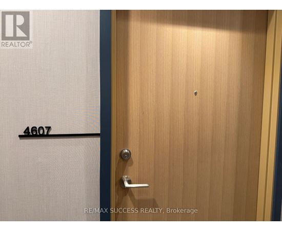 A door with a handle and a number 4607 on the wall.