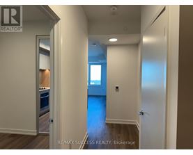 A hallway with a door on the left and a window on the right.