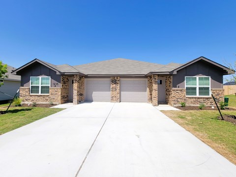 A two-story house with a garage and a driveway.