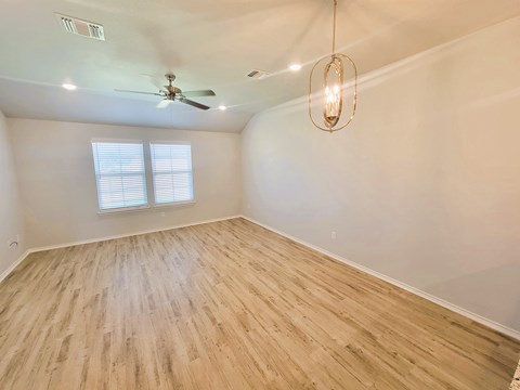 A room with a ceiling fan and a light hanging from the ceiling.