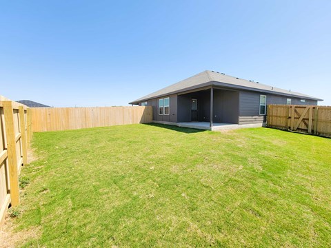 A house with a grey roof and a wooden fence.