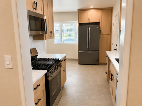 A kitchen with a black stove top oven and a black refrigerator.