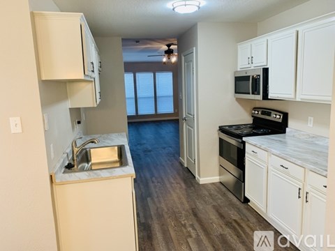 A kitchen with white cabinets and a black stove top oven.