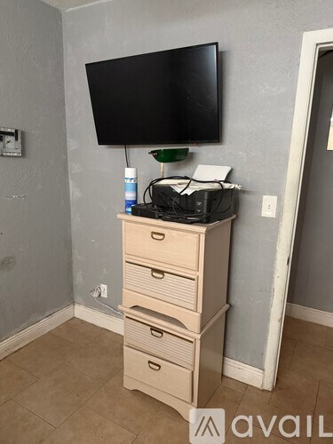 A tall wooden cabinet with a flat screen TV mounted above it.
