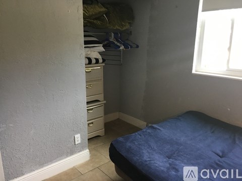 A room with a bed, a dresser, and a window.