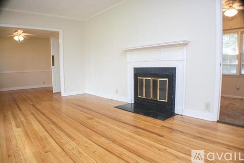 A living room with a fireplace and wood flooring.