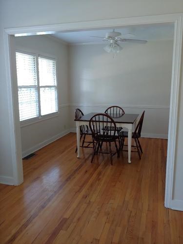 A dining room with a table and chairs.