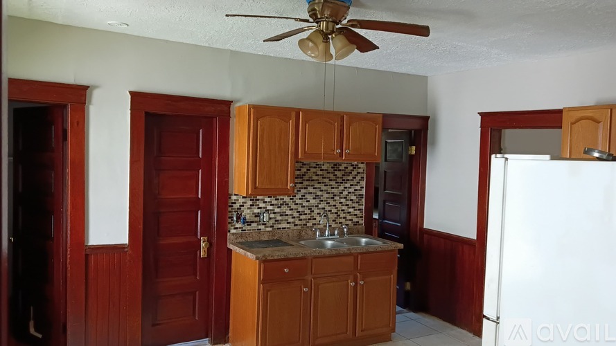 A kitchen with wooden cabinets and a white refrigerator.