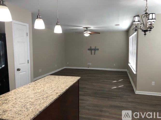 A room with a granite countertop and a ceiling fan.