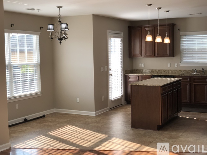 A kitchen with brown cabinets and a marble countertop.