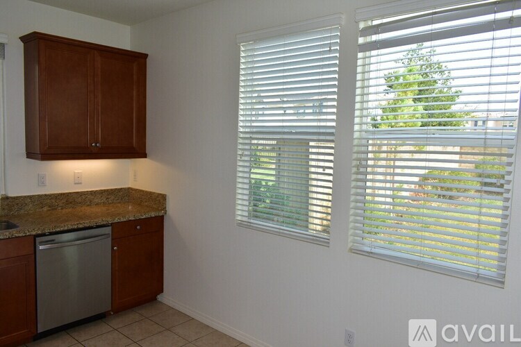 A kitchen with wooden cabinets and a granite countertop.