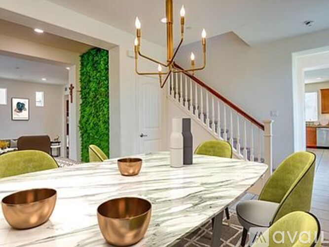 A dining room with a long table and green chairs.