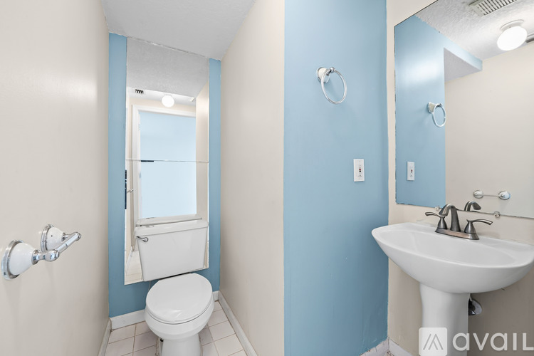 A bathroom with blue walls and a white toilet.