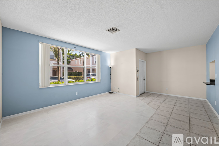 A spacious room with a large window and a view of a building outside.