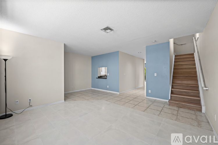 A spacious room with a staircase leading to the upper floor.