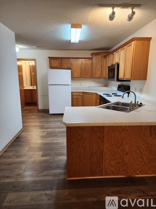 A kitchen with wooden cabinets and a white refrigerator.