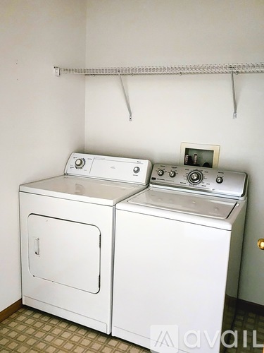 A white washing machine and dryer in a small laundry room.