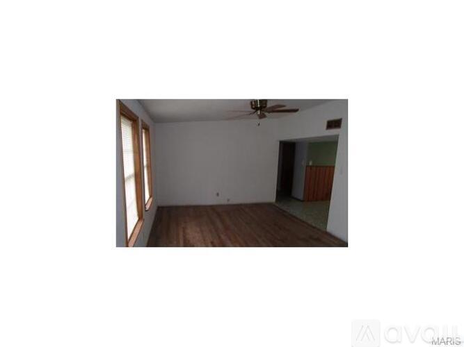 A room with a ceiling fan and a window.