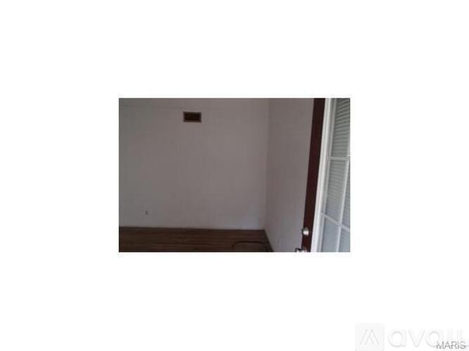 A room with a white wall and a brown floor.