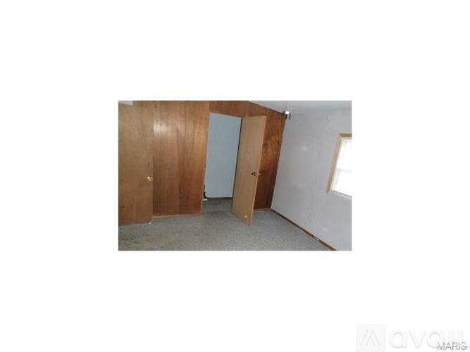 A room with a white wall and a wooden door.